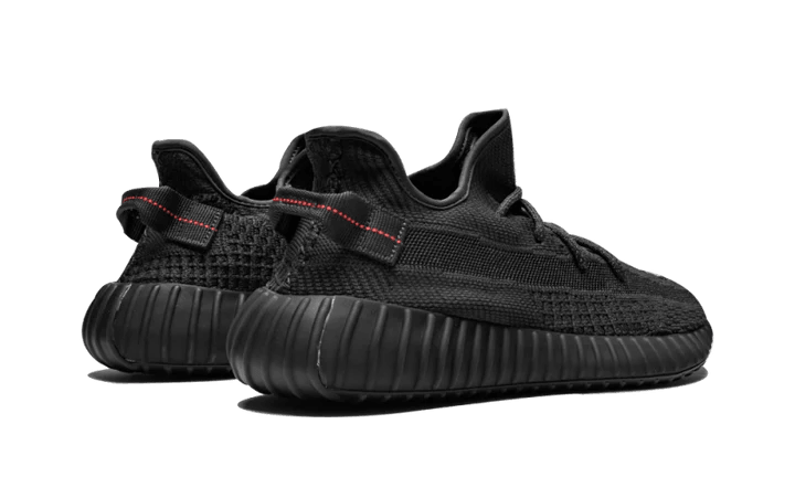 Baskets basses noires Yeezy Boost 350 V2 avec semelle épaisse et détail rouge, vue arrière