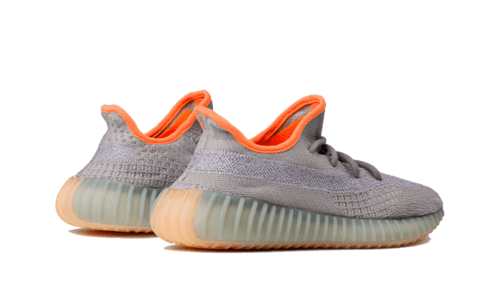 Baskets basses gris et orange style Yeezy Boost 350, semelle en gomme, posées sur fond neutre